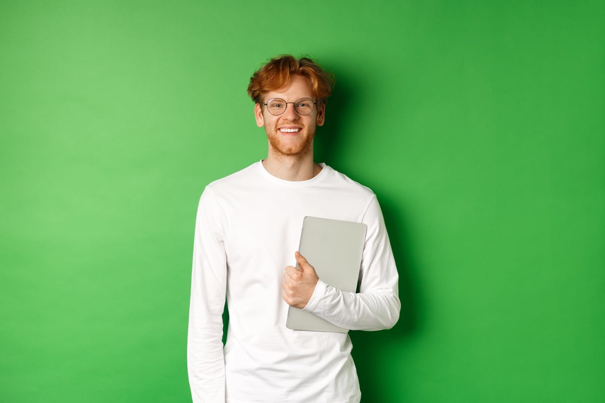 Portrait of smiling man holding digital tablet against green background